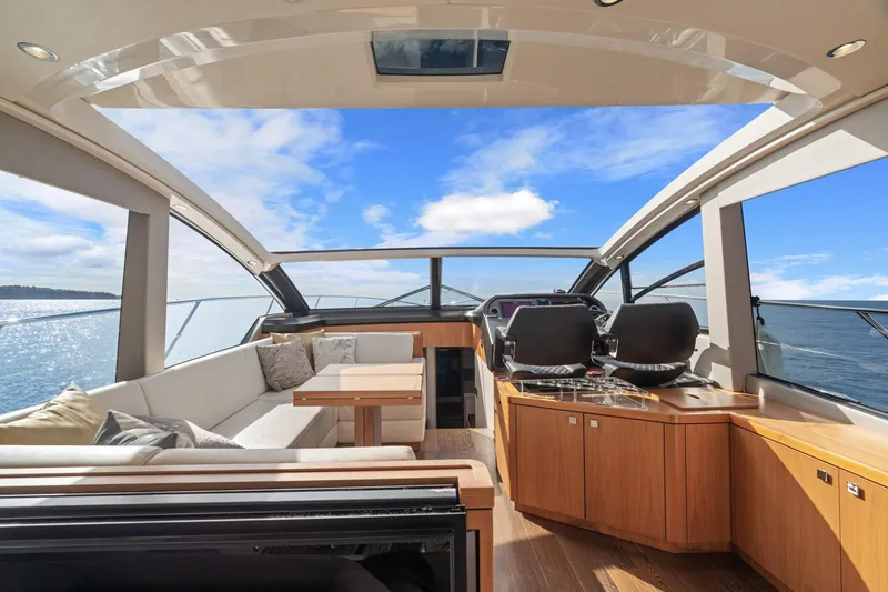 Slide: The Image of 2019 Sunseeker Predator 57 yacht cruising on a sunny day with scenic coastal view. - 29