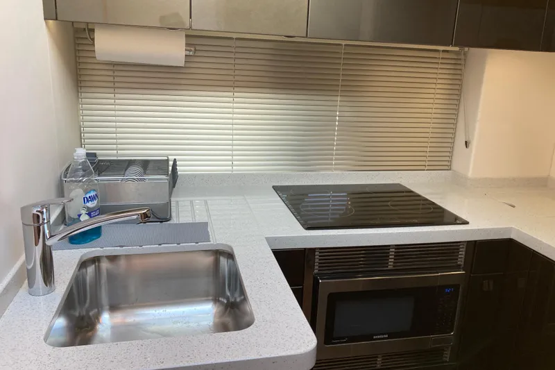 Slide: The Image of 2019 Sunseeker Predator 57 yacht on calm water near coastal cityscape. - 6