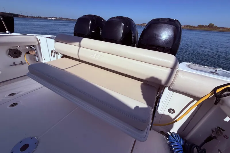 Slide: The Image of 2020 Boston Whaler 350 Outrage boat with cushioned seating and triple outboard motors. - 10