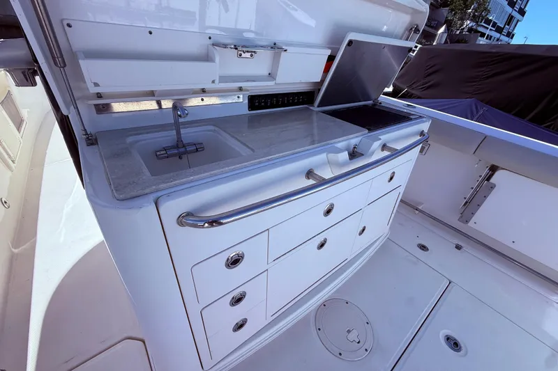 Slide: The Image of 2020 Boston Whaler 350 Outrage boat kitchen with sink and storage drawers. - 13