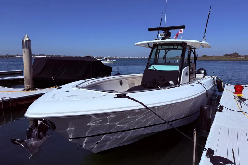Slide: The Image of 2020 Boston Whaler 350 Outrage docked at marina, clear blue sky. - 4