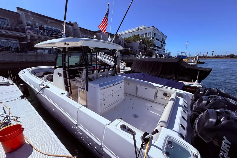 Slide: The Image of 2020 Boston Whaler 350 Outrage docked, featuring spacious deck and American flag. - 6