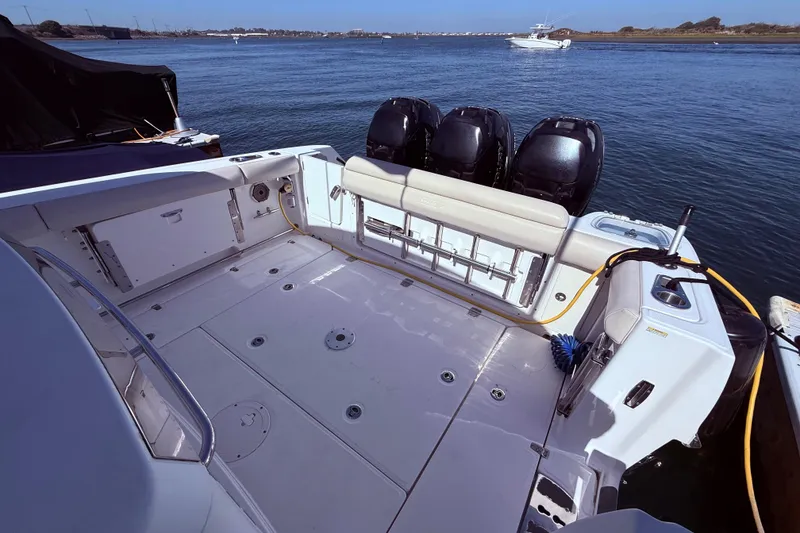 Slide: The Image of 2020 Boston Whaler 350 Outrage boat deck with triple outboard engines on water. - 8