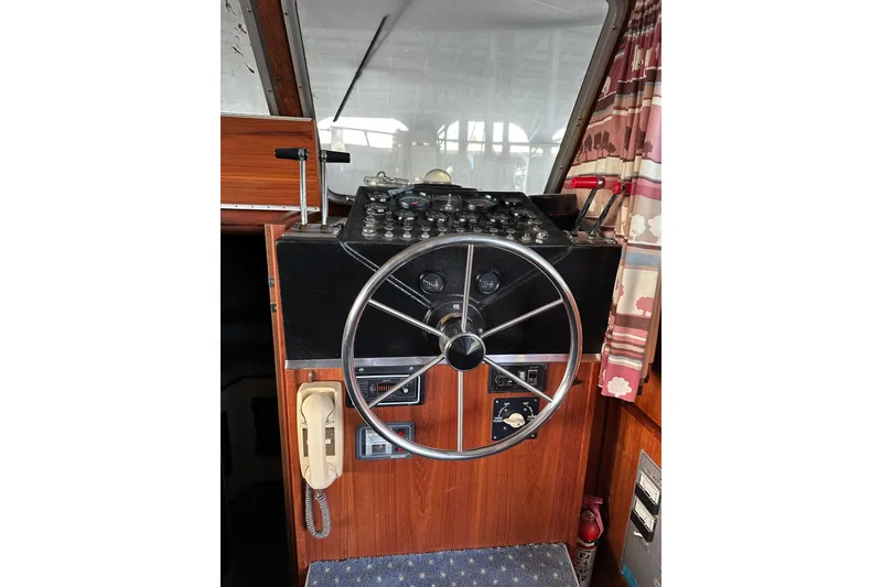 Slide: The Image of 1984 Tollycraft 34 aft cabin helm with steering wheel and control panel. - 12