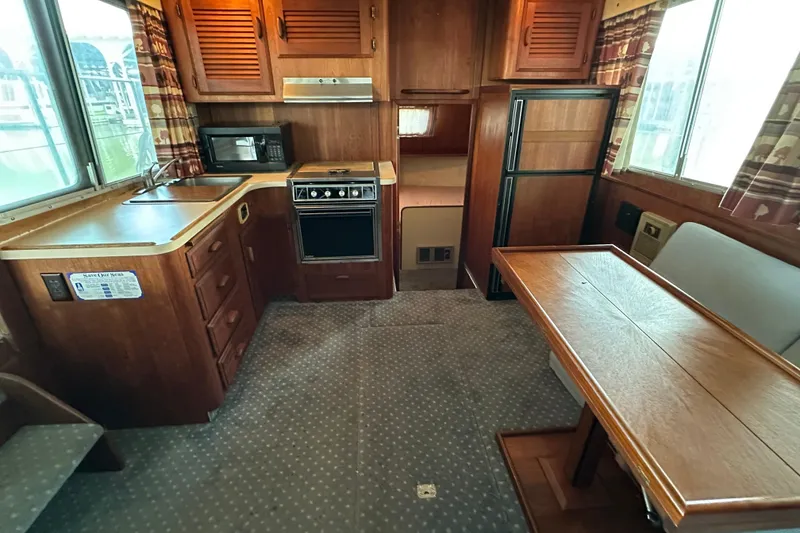 Slide: The Image of 1984 Tollycraft 34 aft cabin interior with kitchen and dining area. - 2