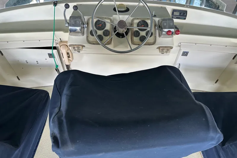 Slide: The Image of 1984 Tollycraft 34 aft cabin helm with covered seats and classic controls. - 22