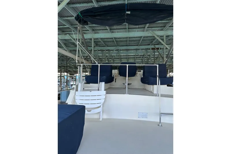 Slide: The Image of 1984 Tollycraft 34 aft cabin boat interior with blue seating under a covered dock. - 24