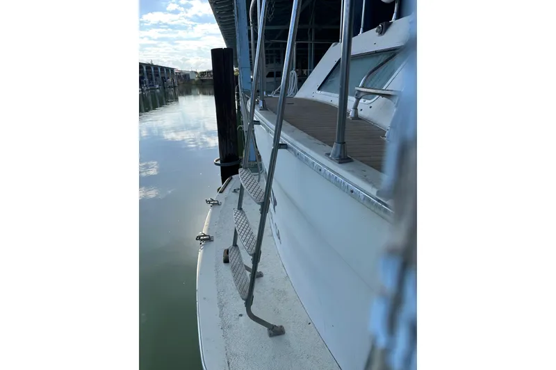 Slide: The Image of 1984 Tollycraft 34 aft cabin boat docked, showing side view and ladder. - 25