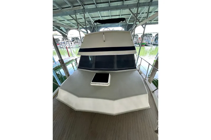 Slide: The Image of 1984 Tollycraft 34 aft cabin boat docked under a covered marina. - 28