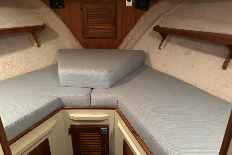Slide: The Image of 1984 Tollycraft 34 aft cabin interior with cushioned V-berth and wooden accents. - 5