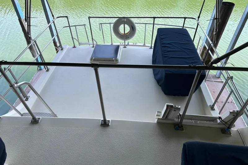 Slide: The Image of 1984 Tollycraft 34 aft cabin boat deck with railing and covered seating. - 6