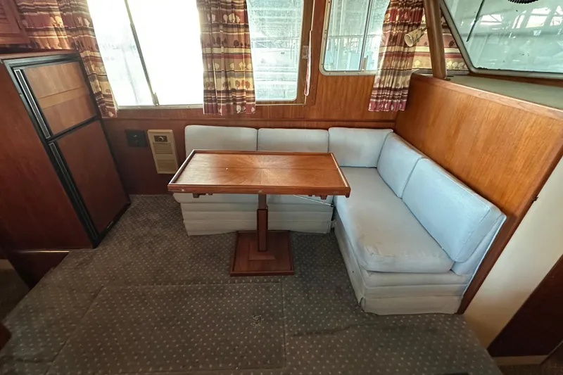 Slide: The Image of 1984 Tollycraft 34 aft cabin interior with dining area and wooden table. - 7