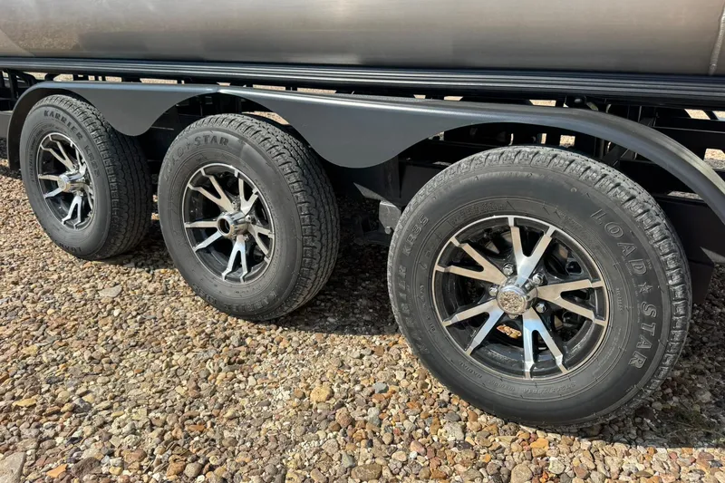 Slide: The Image of 2025 Barletta LUSSO 25UCAT trailer wheels on gravel surface. - 40