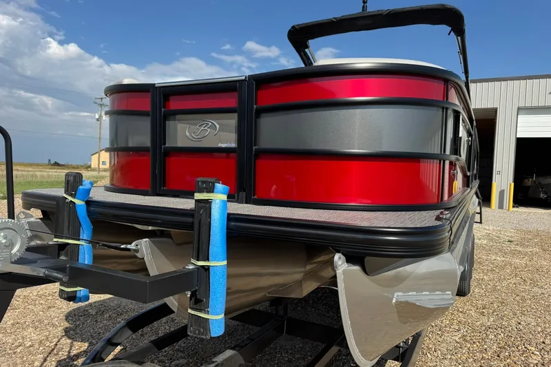 Slide: The Image of 2025 Barletta LUSSO 25UCAT pontoon boat with red and gray exterior on a trailer. - 5