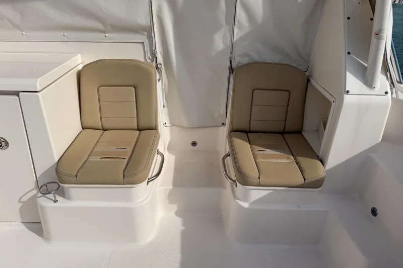 Slide: The Image of 2016 Pursuit OS 355 Offshore boat interior with beige seating and white accents. - 14