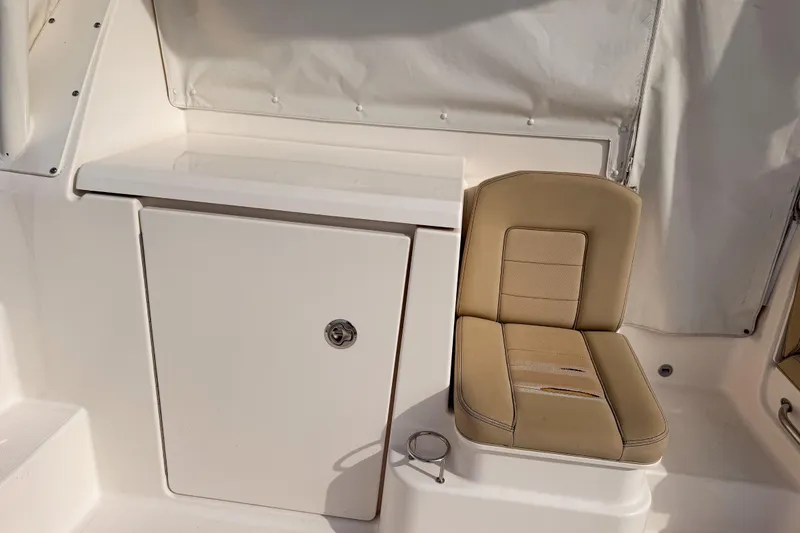 Slide: The Image of 2016 Pursuit OS 355 Offshore boat interior with beige seating and storage compartment. - 16