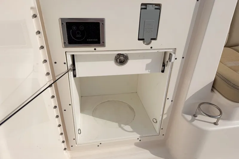 Slide: The Image of 2016 Pursuit OS 355 Offshore storage compartment with control panel and cup holder. - 18