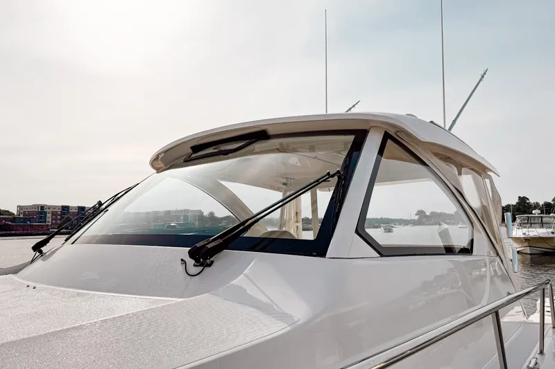 Slide: The Image of 2016 Pursuit OS 355 Offshore boat docked, showcasing sleek design and windshield wipers. - 2