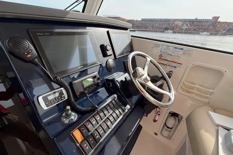 Slide: The Image of Cockpit of 2016 Pursuit OS 355 Offshore boat with navigation equipment and steering wheel. - 25