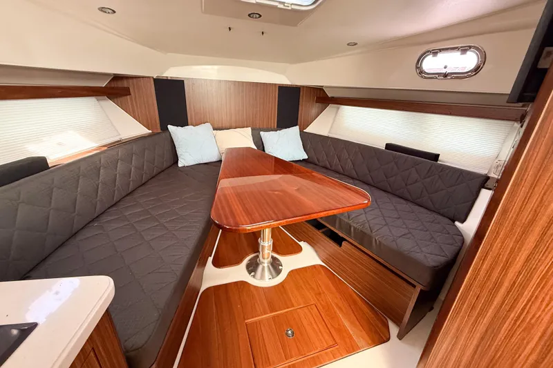 Slide: The Image of 2016 Pursuit OS 355 Offshore cabin interior with wood finishes and cushioned seating. - 33