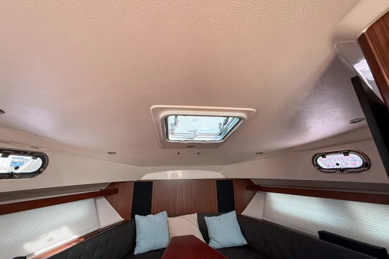 Slide: The Image of Interior cabin of 2016 Pursuit OS 355 Offshore boat with skylight and cushions. - 35