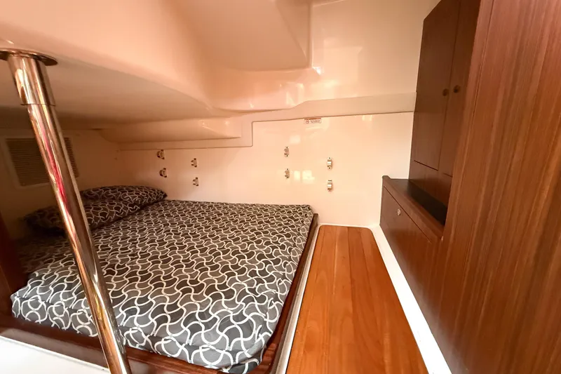 Slide: The Image of 2016 Pursuit OS 355 Offshore cabin interior with bed and wooden cabinetry. - 37