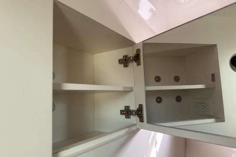 Slide: The Image of Open cabinet with shelves inside a 2016 Pursuit OS 355 Offshore boat. - 43