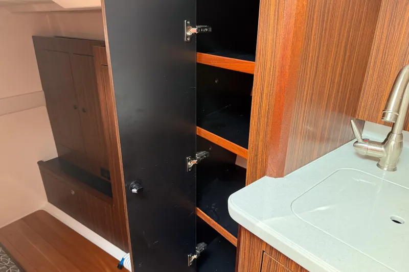 Slide: The Image of 2016 Pursuit OS 355 Offshore interior with open wooden cabinet and modern sink. - 45