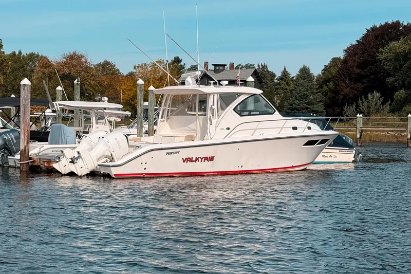 Slide: The Image of 2016 Pursuit OS 355 Offshore boat docked in a scenic marina setting. - 5