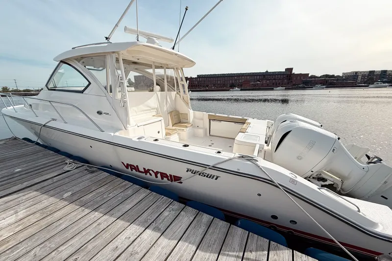 Slide: The Image of 2016 Pursuit OS 355 Offshore boat docked by the water, showcasing sleek design. - 6