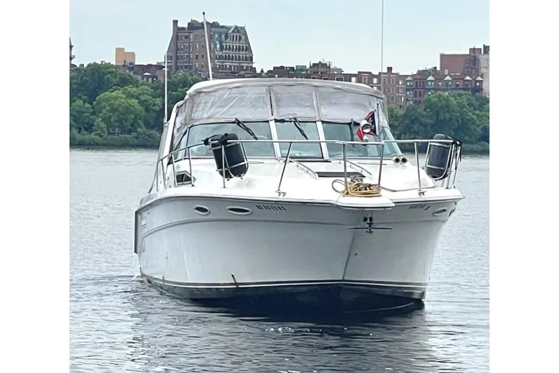 Slide: The Image of 1990 Sea Ray 350 Sundancer boat on water, cityscape background. - 1