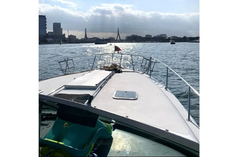 Slide: The Image of 1990 Sea Ray 350 Sundancer cruising on a sunny day with city skyline view. - 3