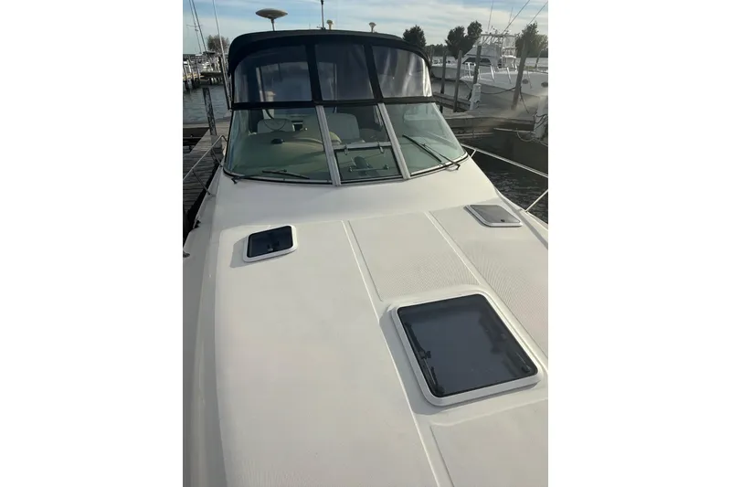 Slide: The Image of 2000 Sea Ray 310 Sundancer boat docked, showcasing sleek design and spacious deck. - 10