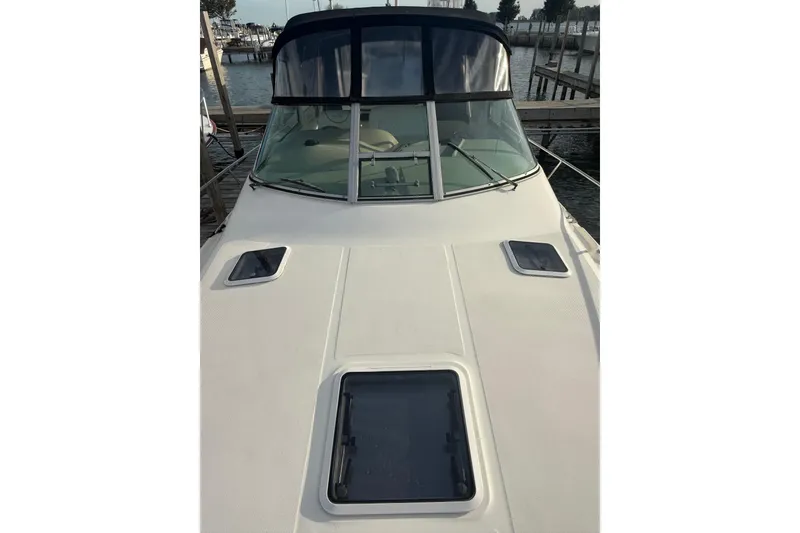 Slide: The Image of 2000 Sea Ray 310 Sundancer boat docked, featuring sleek design and spacious deck. - 11