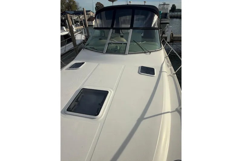 Slide: The Image of 2000 Sea Ray 310 Sundancer boat docked at marina, front deck view. - 12