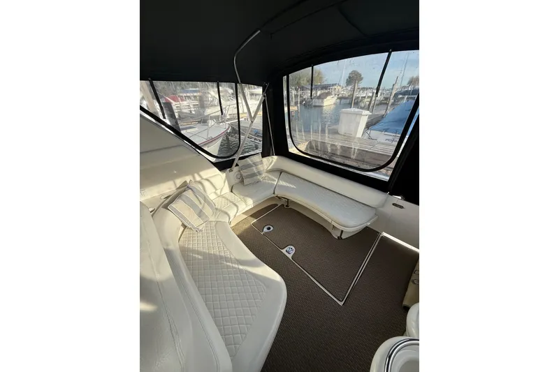 Slide: The Image of Interior of 2000 Sea Ray 310 Sundancer with white seating and marina view. - 19