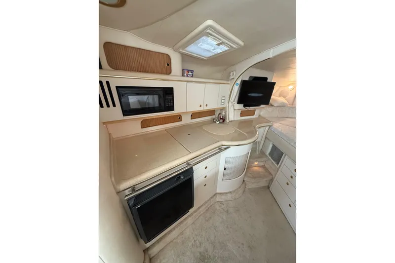 Slide: The Image of Interior of 2000 Sea Ray 310 Sundancer yacht with kitchenette and modern amenities. - 24