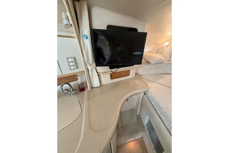 Slide: The Image of Interior of 2000 Sea Ray 310 Sundancer with TV, sink, and cozy seating area. - 26