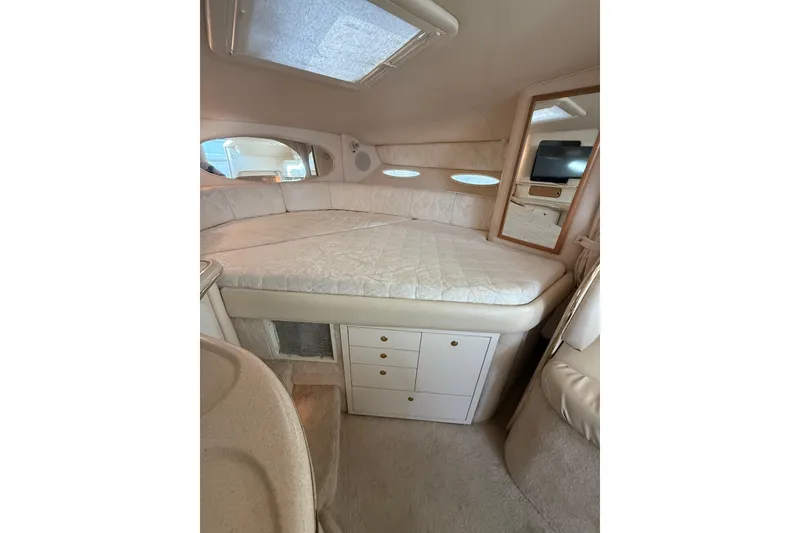 Slide: The Image of 2000 Sea Ray 310 Sundancer cabin interior with bed, storage, and mirror. - 27