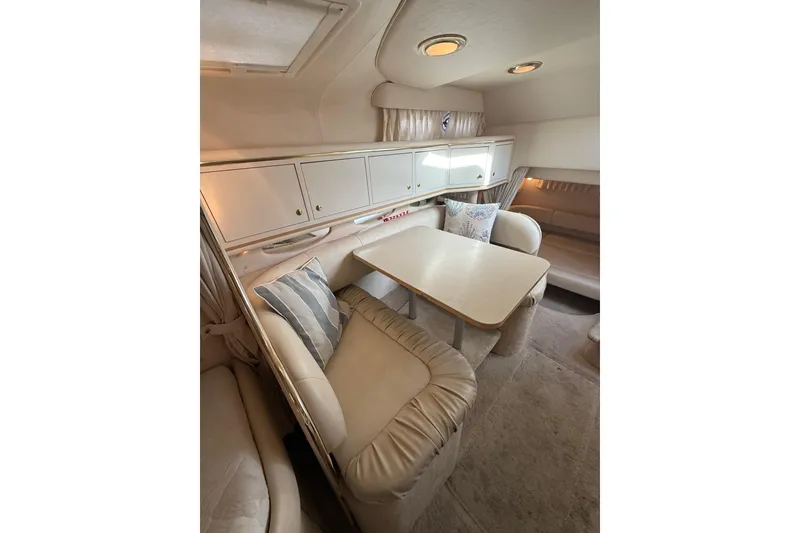 Slide: The Image of 2000 Sea Ray 310 Sundancer cabin interior with cozy seating and dining area. - 28