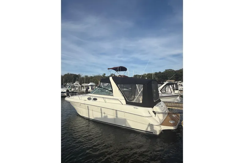 Slide: The Image of 2000 Sea Ray 310 Sundancer boat docked at marina under clear blue sky. - 3