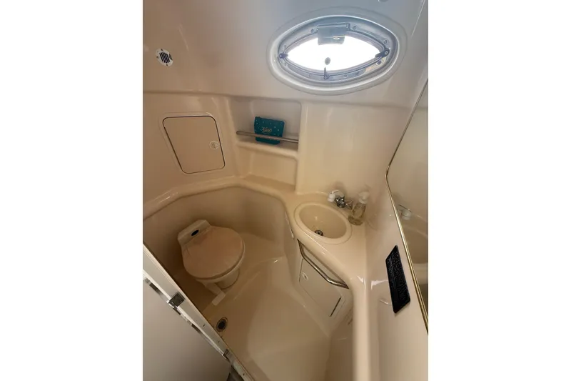 Slide: The Image of 2000 Sea Ray 310 Sundancer bathroom with sink, toilet, and porthole window. - 30