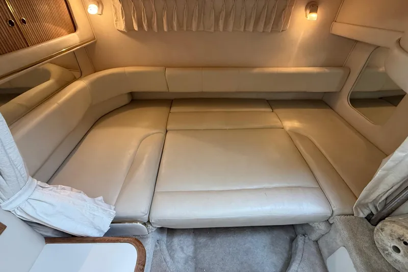 Slide: The Image of 2000 Sea Ray 310 Sundancer cabin interior with beige leather seating and ambient lighting. - 31