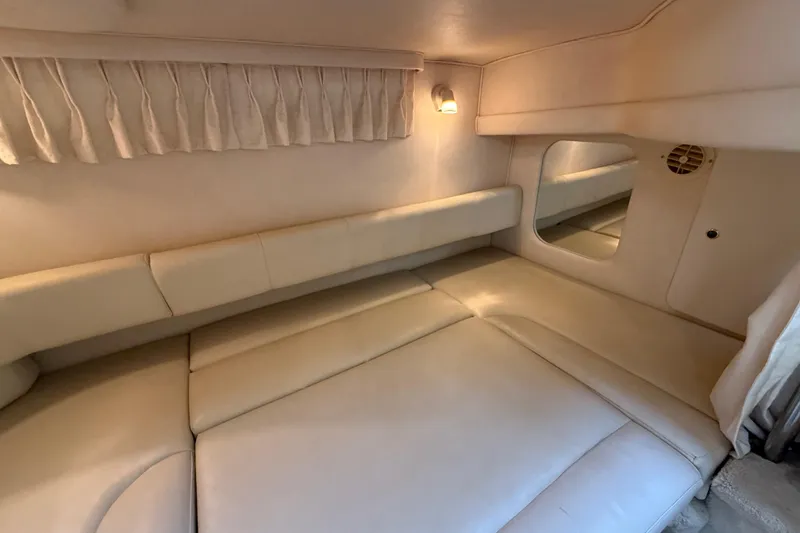 Slide: The Image of 2000 Sea Ray 310 Sundancer cabin interior with beige upholstery and ambient lighting. - 32