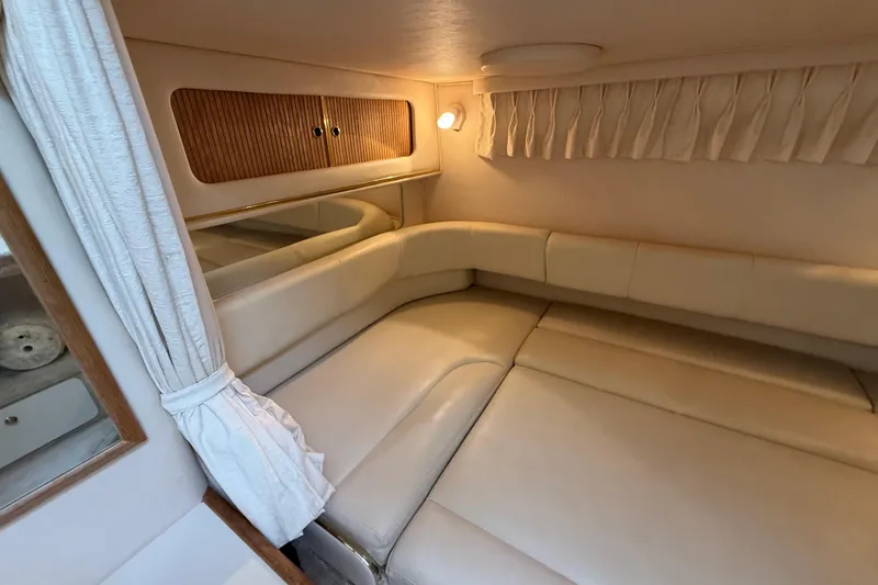 Slide: The Image of Interior cabin of 2000 Sea Ray 310 Sundancer with beige seating and wooden accents. - 33