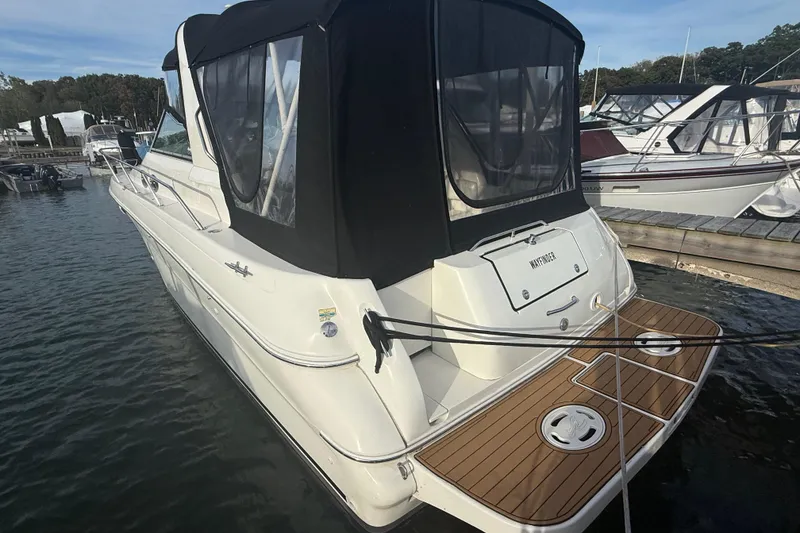 Slide: The Image of 2000 Sea Ray 310 Sundancer boat docked, featuring a sleek design and black canopy. - 5