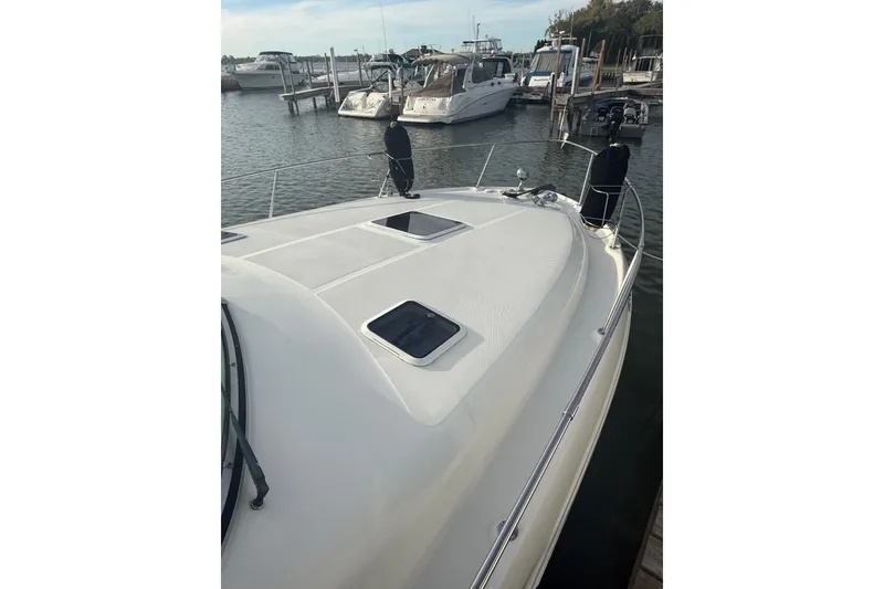 Slide: The Image of 2000 Sea Ray 310 Sundancer docked at marina, showcasing sleek deck design. - 7