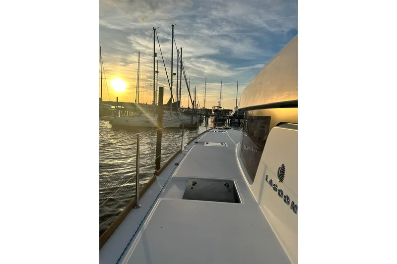 Slide: The Image of Lagoon 52 F yacht docked at sunset, 2021 model, with serene marina view. - 12