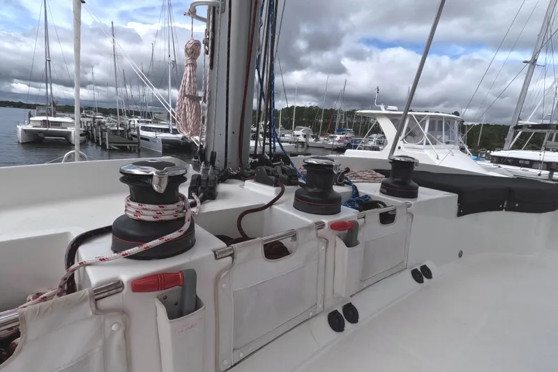 Slide: The Image of Lagoon 51 yacht deck with winches and ropes, docked at a marina under cloudy skies. - 15