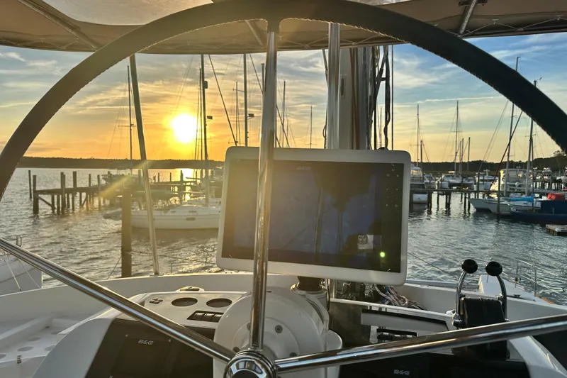 Slide: The Image of Helm of 2021 Lagoon 52 F catamaran at sunset in marina. - 16